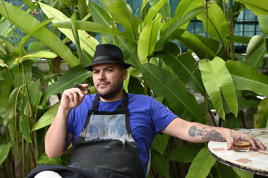 Le chef cubain Raulito Bazuk fume un cigare sur la terrasse de son restaurant Grados