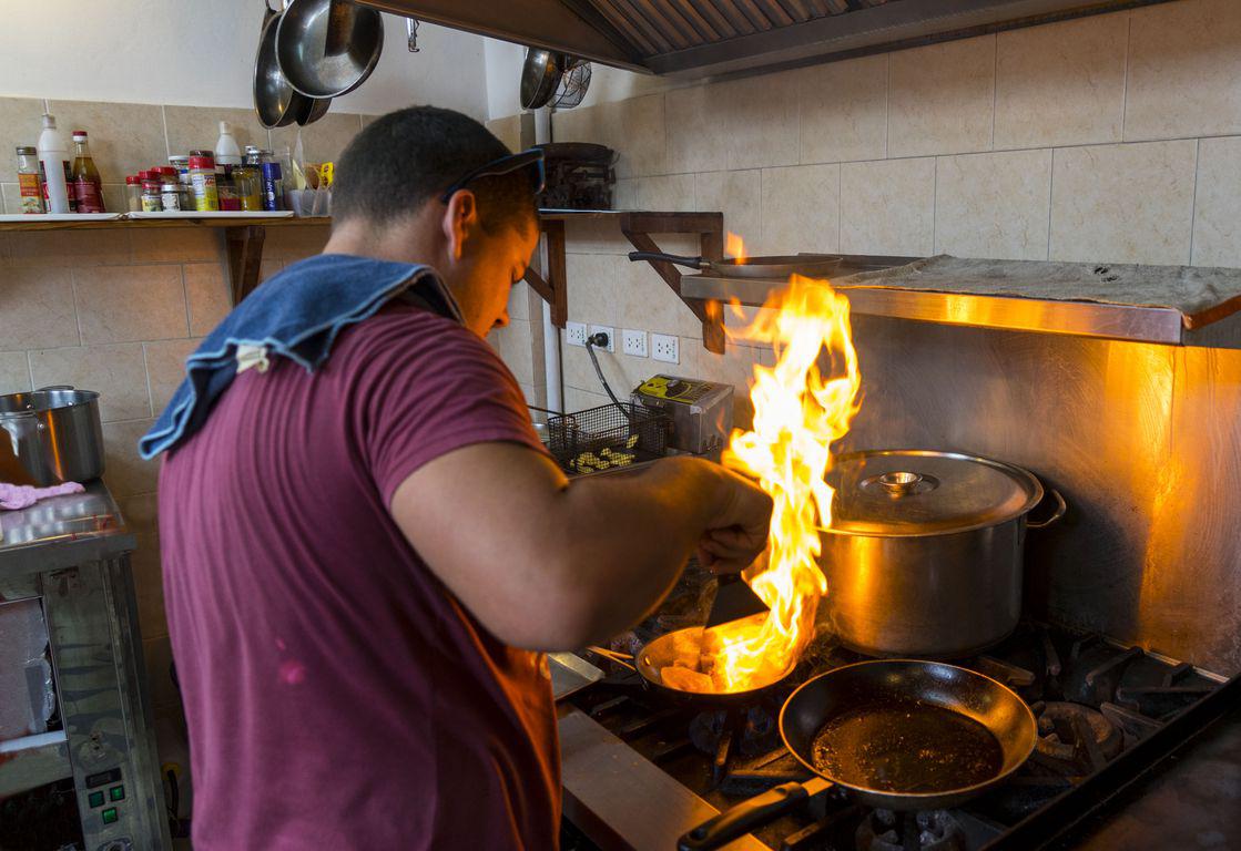 Raulito cuisine un plat dans la cuisine de son restaurant Grados à La Havane